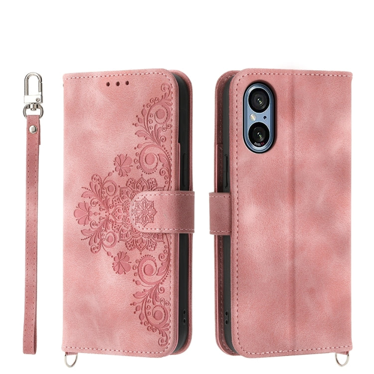 Pink embossed floral wallet phone case with wrist strap and magnetic closure