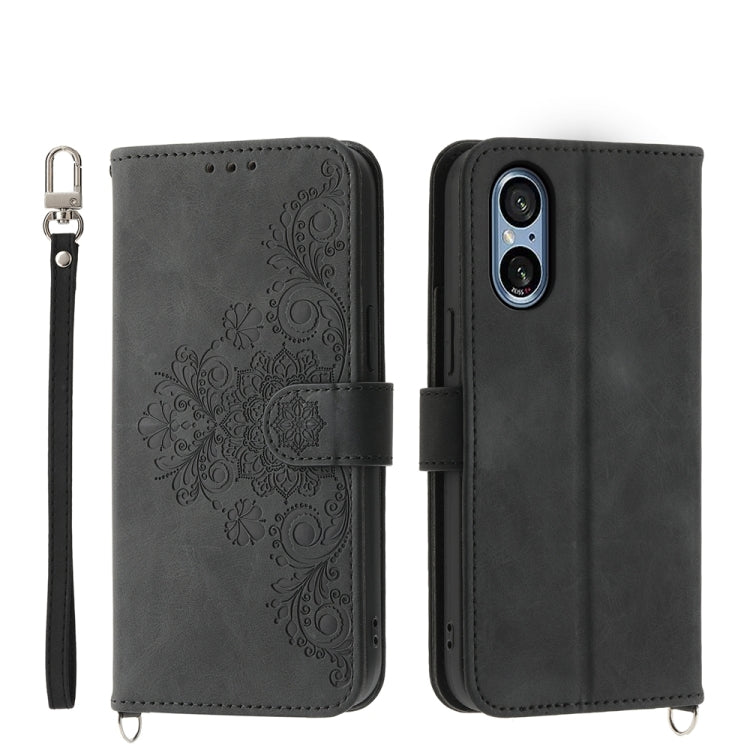 Black embossed floral wallet phone case with wrist strap and magnetic closure