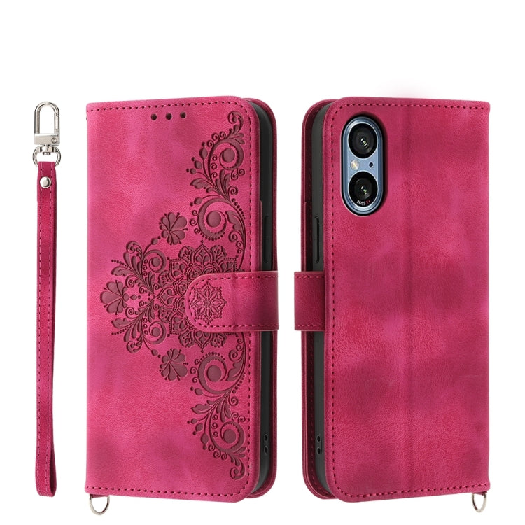 Magenta embossed floral wallet phone case with wrist strap and magnetic closure