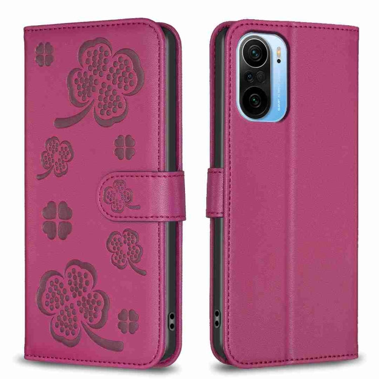Four-leaf embossed leather phone case with folio flap, magenta-purple with clover pattern.