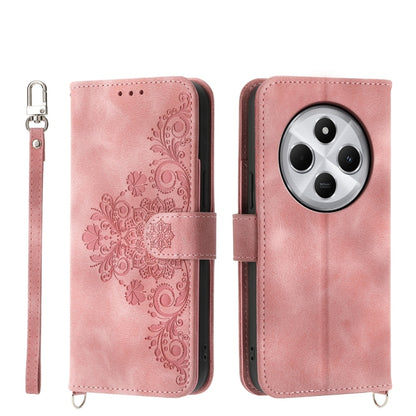 Pink floral embossed wallet phone case with camera cutout and wrist strap
