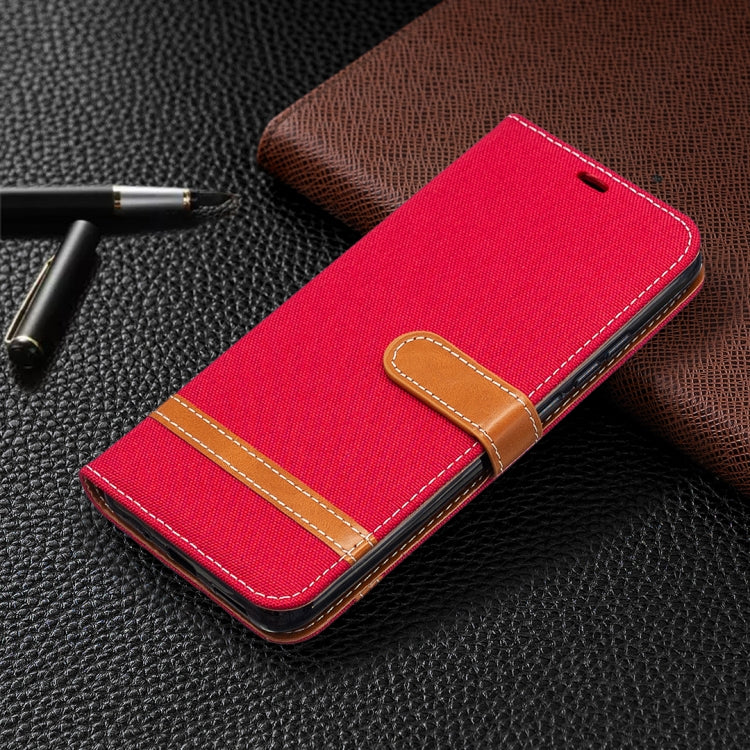 Red denim-texture flip phone wallet case with tan wrap strap and stitched edges