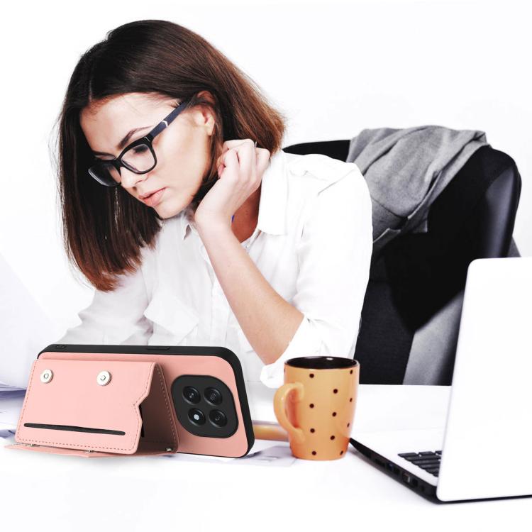 Pink folio phone case with card slot flap and wrist strap, shown in desk setup