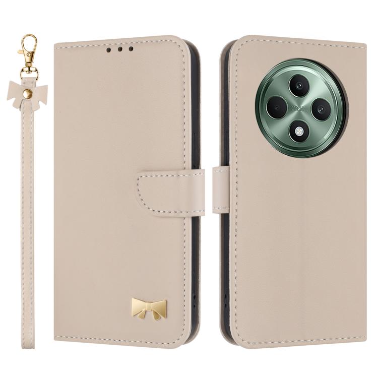 Beige leather phone case with hand strap, folio flap, metal bow charm, camera cutout.