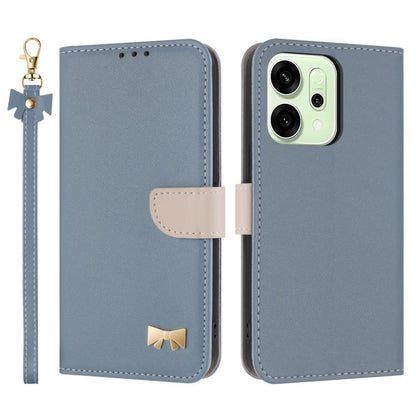 Blue leather-style phone case with wrist strap, folio flap, and gold bow emblem