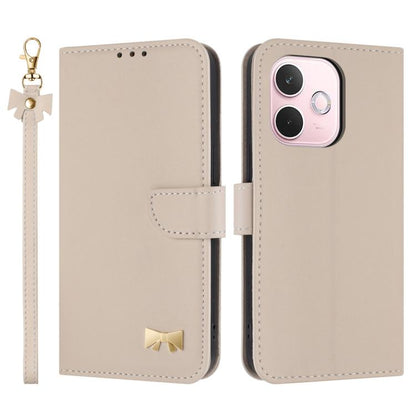 Beige leather-style phone case with wrist strap, folio flap, and gold bow emblem