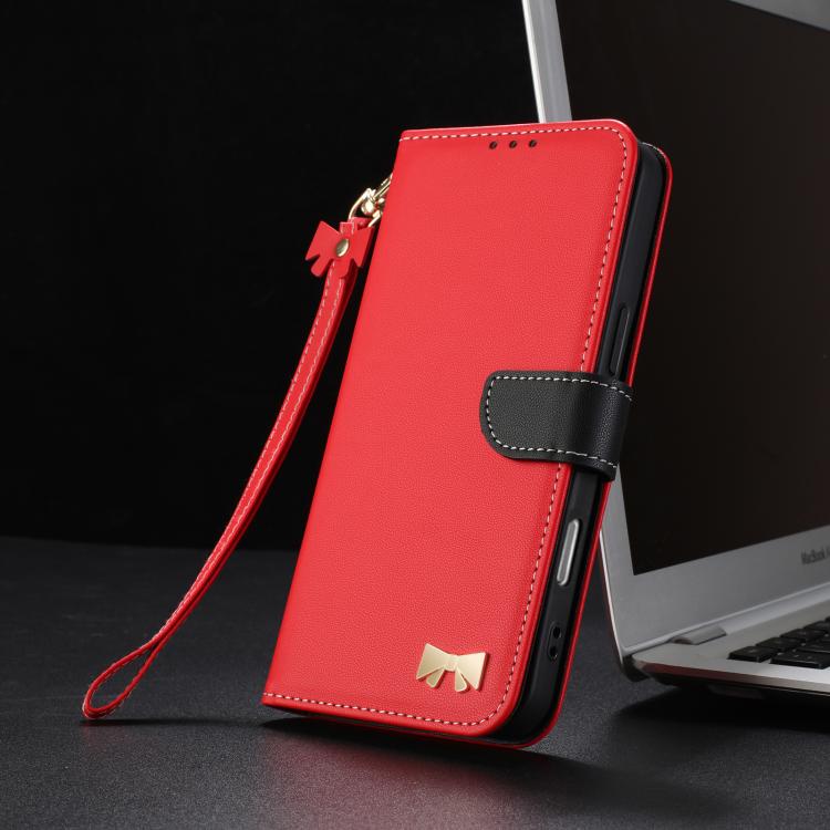 Red leather-look phone case with hand strap, foldover flap, and gold bow emblem