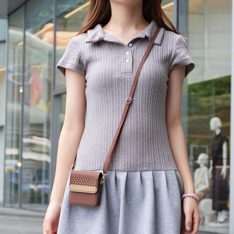 Brown leather crossbody flip phone bag worn across the body with cutout floral front