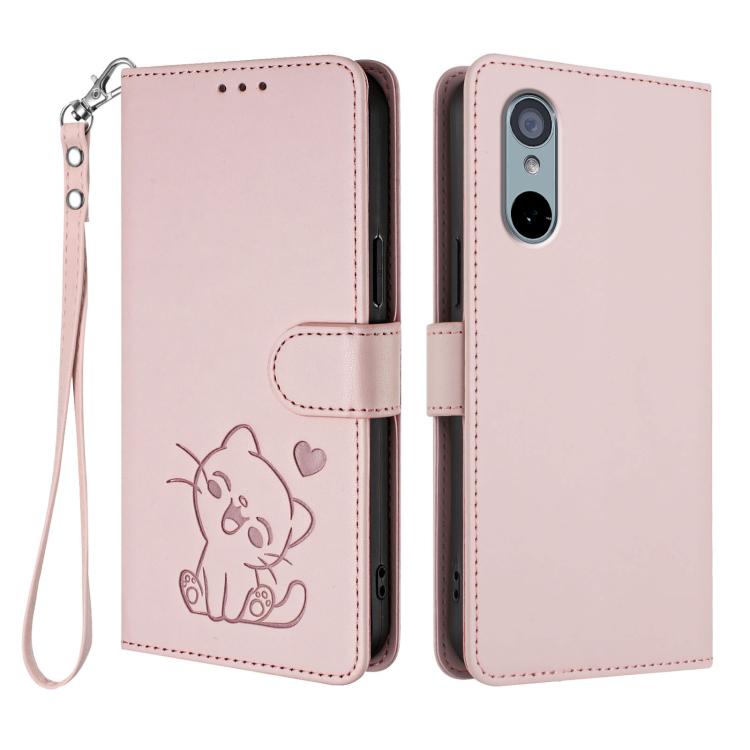 Light pink leather-style phone case with embossed cat and heart pattern and wrist strap