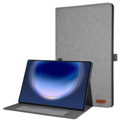 Grey fabric tablet case with flip cover and stand, viewed with tablet device in front