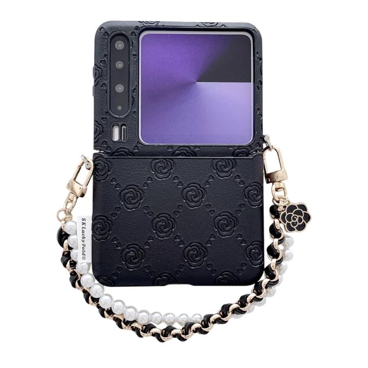 Black embossed phone case with rose pattern, side buckle, and chain wrist strap