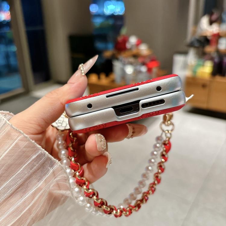 Side view of silver phone case with red trim and pearl-bead chain strap