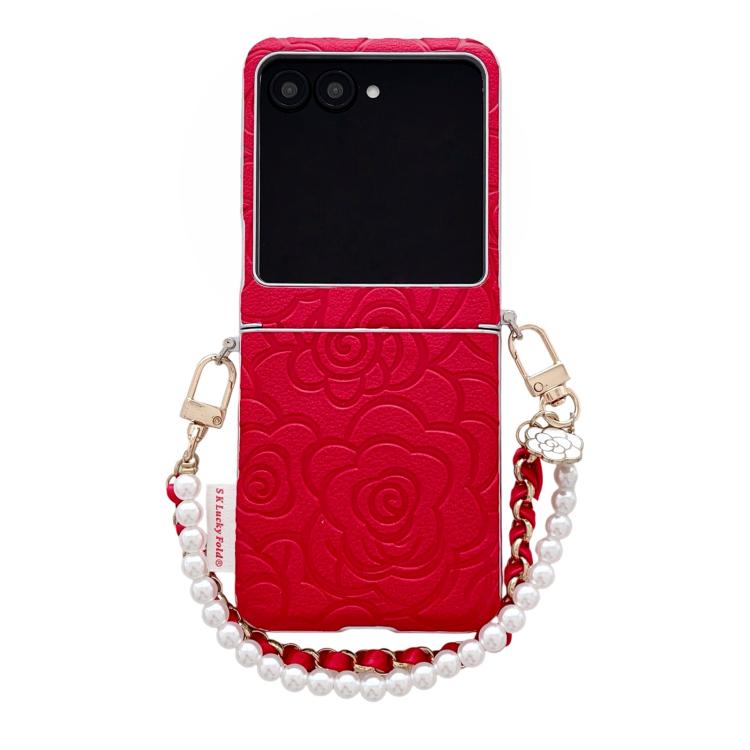 Red embossed camellia phone case with side buckle and pearl bracelet strap.