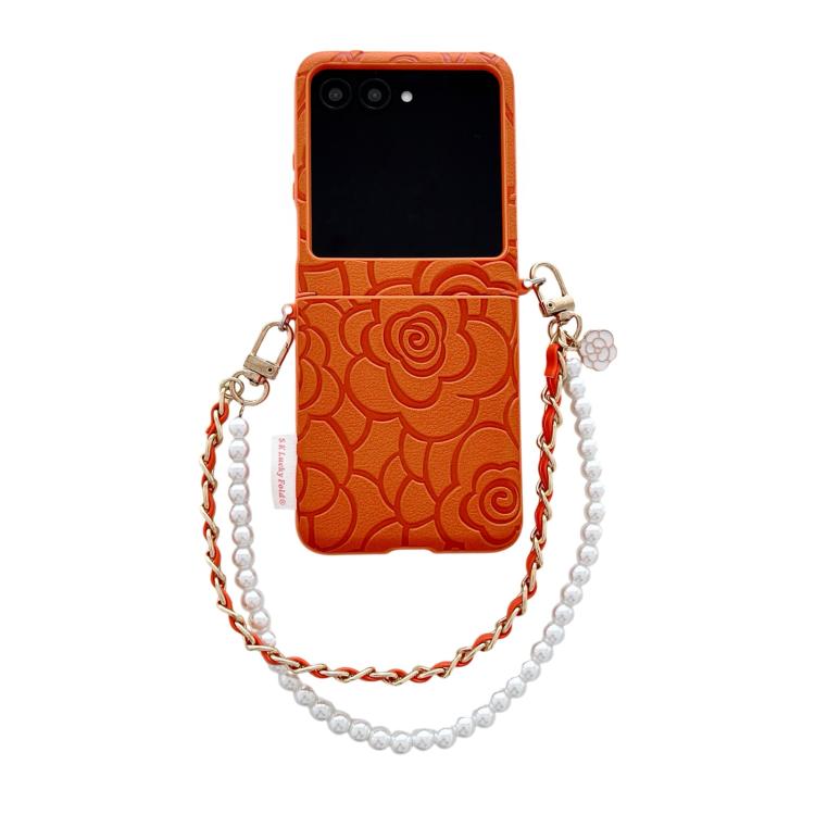 Orange embossed camellia phone case with side buckle and pearl bracelet strap.