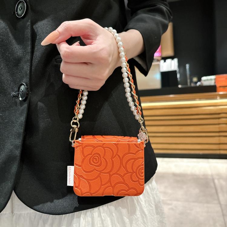 Orange embossed camellia phone case with side buckle and pearl chain crossbody strap