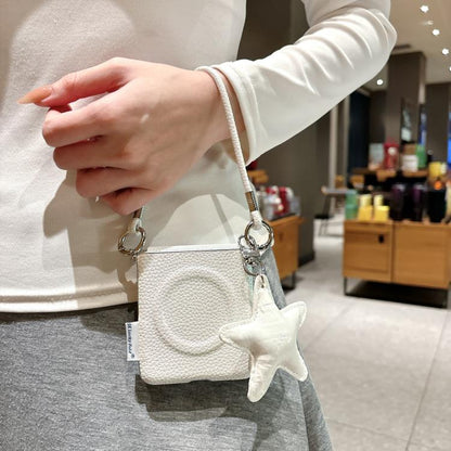 White textured phone case with star charm and wrist strap, held in hand