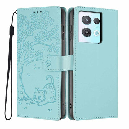 Light blue tree-cat embossed flip vegan leather phone case with wrist strap.