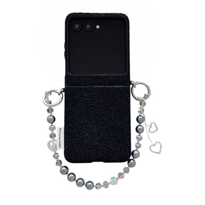 Black lace-embossed phone case with dual metal hooks and beaded wrist strap