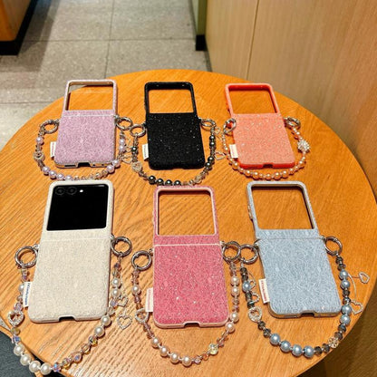Assorted lace-embossed phone cases with wrist straps in multiple colors on a table