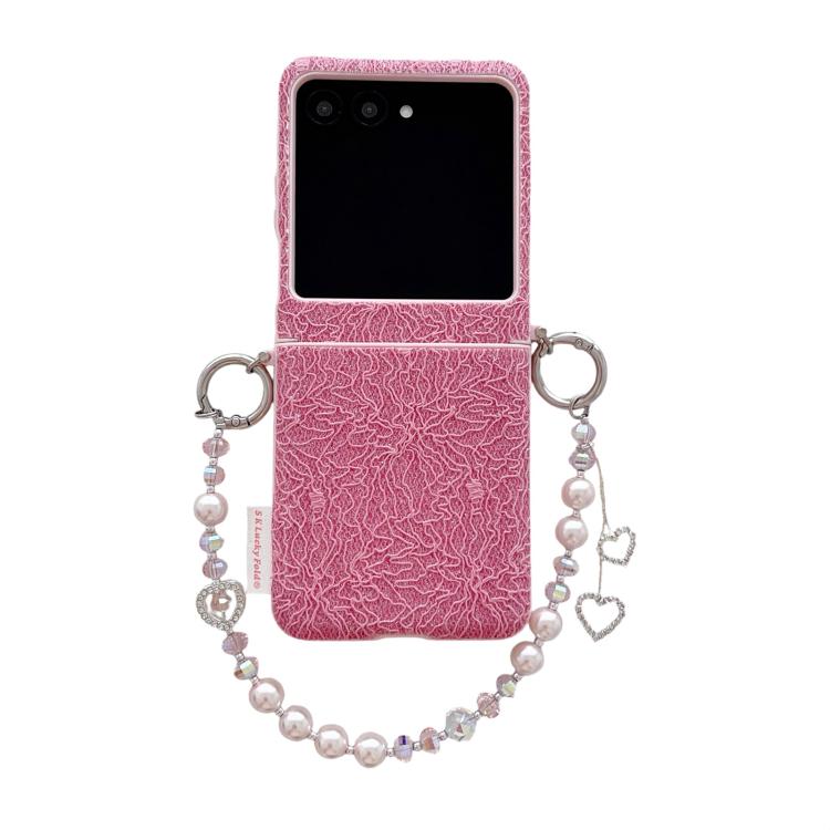 Pink lace-embossed phone case with dual metal hooks and beaded wrist strap