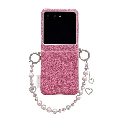 Pink lace-embossed phone case with dual metal hooks and beaded wrist strap