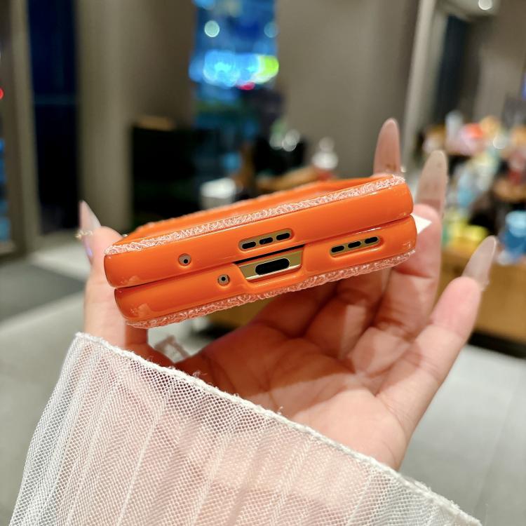 Orange lace-embossed phone case with metal hooks and beaded wrist strap, side cutouts