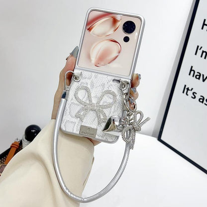 Silver scale-texture bow phone case with wrist strap and dangling heart/chain charm