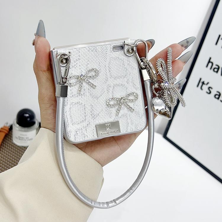 Silver scale-texture bow phone case with wrist strap, dangling charms, and nameplate