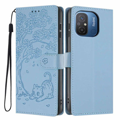 Tree-cat embossed vegan leather flip phone case with wrist strap, light blue.