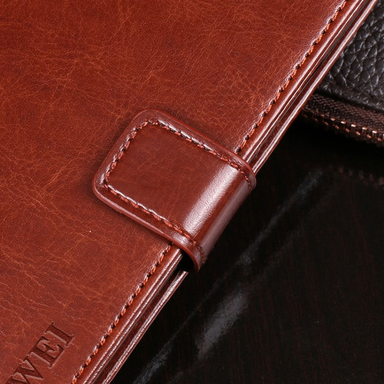 Brown leather phone wallet with stitched corner edge and belt-like closure tab