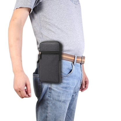 Black fabric phone waist pack with front zip pocket and belt strap on denim pants