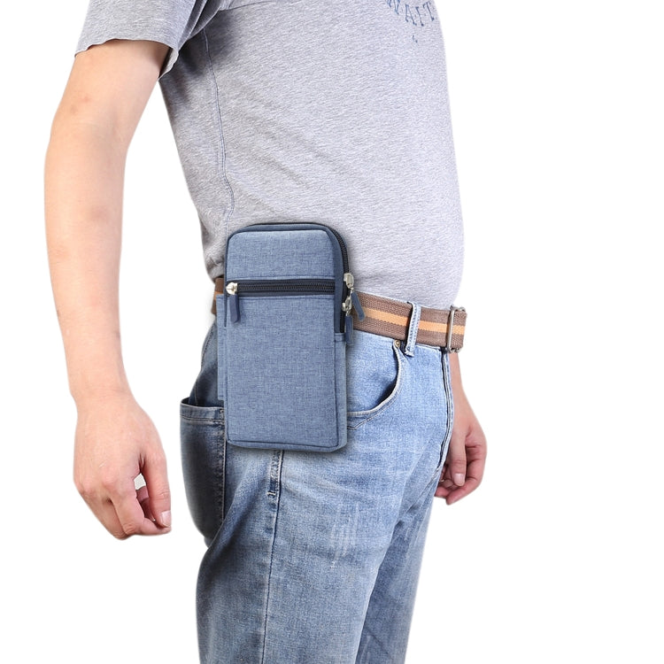 Blue fabric phone waist pack case on belt with front zip pocket on denim jeans