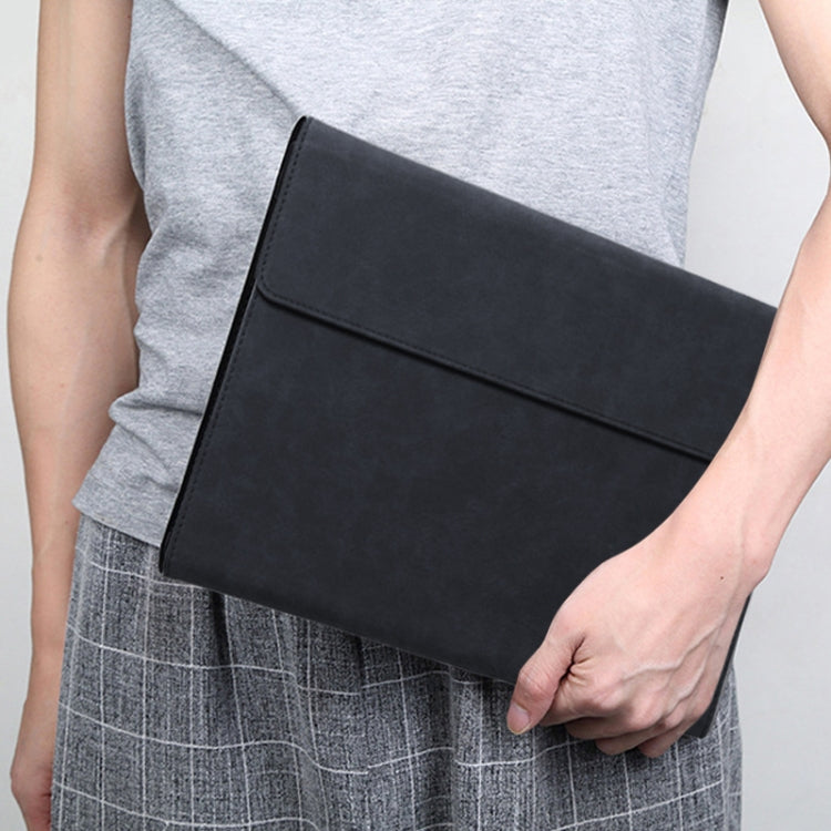 Black laptop sleeve case with front flap, carried by hand