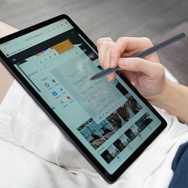 Hand using a stylus pen on a tablet screen with writing and icons