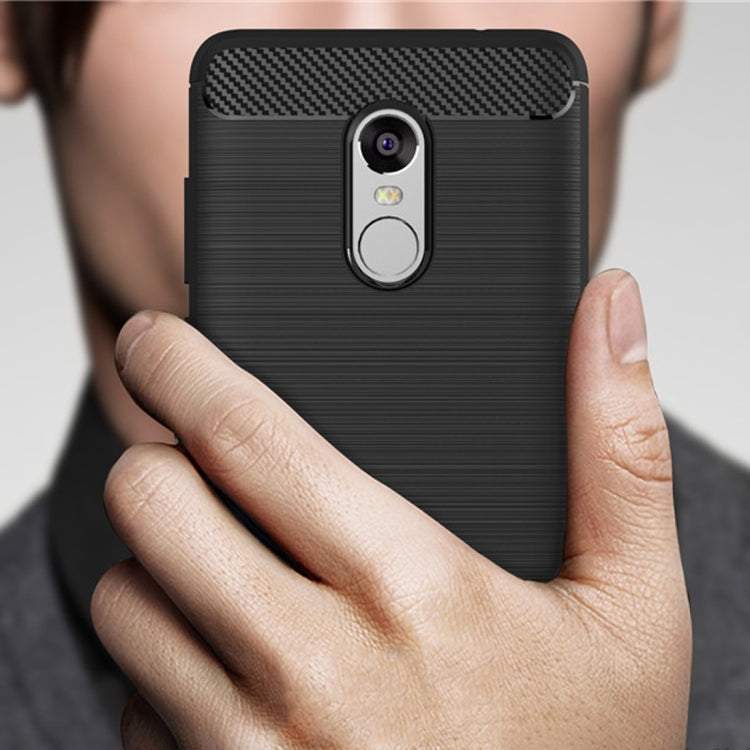 Black brushed TPU phone case with carbon-fiber top and camera cutout, held in hand