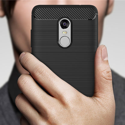 Black brushed TPU phone case with carbon-fiber top and camera cutout, held in hand