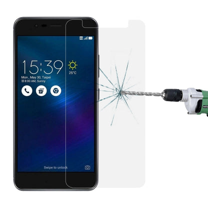 Tempered glass screen protector with spiderweb impact cracks on display