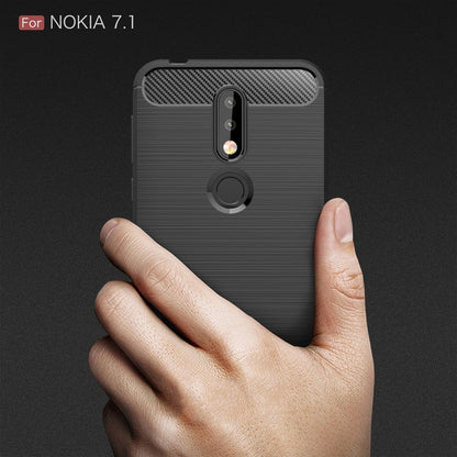 Brushed carbon fiber TPU phone case back in dark color, held in a hand