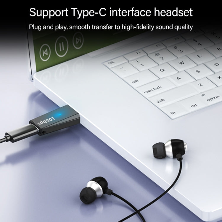 USB 3.1 male-to-USB-C female adapter plugged into laptop USB-C port with headset cable