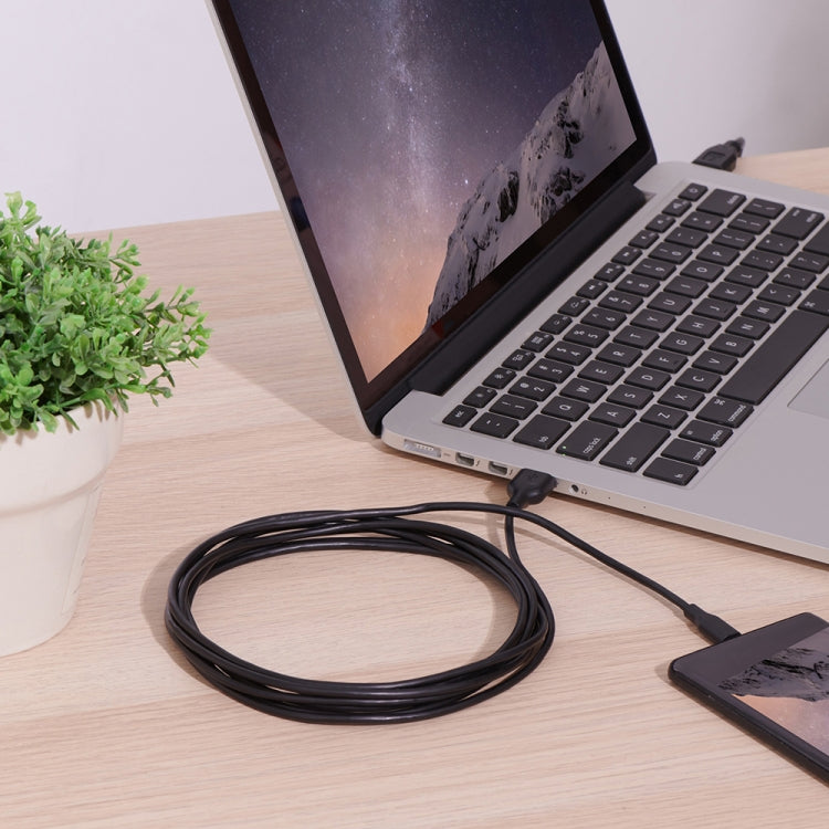 USB-C to USB 2.0 converter cable coiled near a laptop