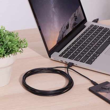 USB-C to USB 2.0 converter cable coiled near a laptop