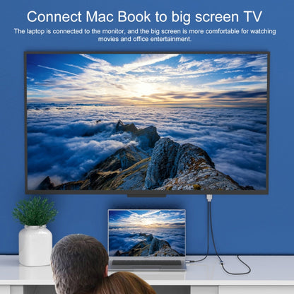 USB-C to HDMI adapter cable connecting laptop to large TV for viewing