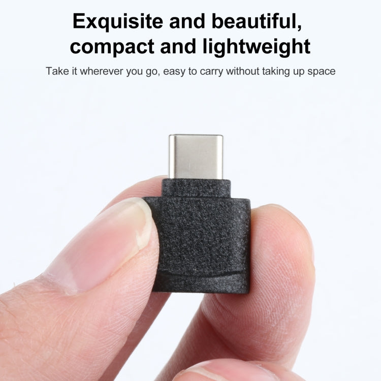 USB-C to TF card reader adapter held in hand, black textured body