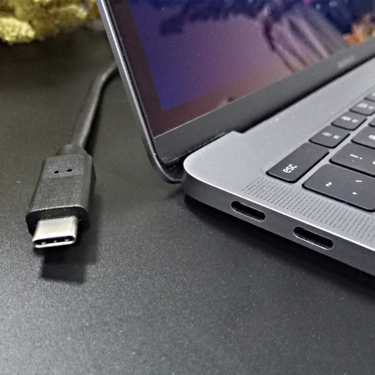 USB Type-C connector plugged into a laptop port with black cable