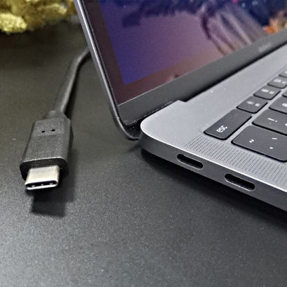 USB Type-C connector plugged into a laptop port with black cable