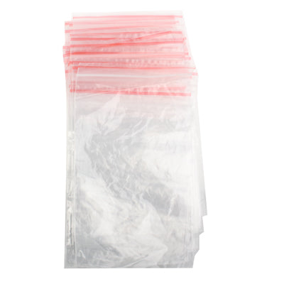Clear self-adhesive plastic bag with red top seal strip, upright