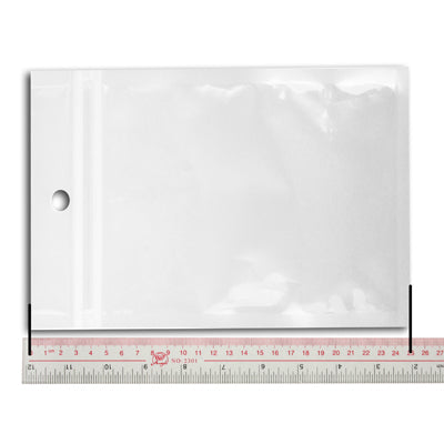 Resealable zip lock plastic bag, white, with hang hole, shown with ruler