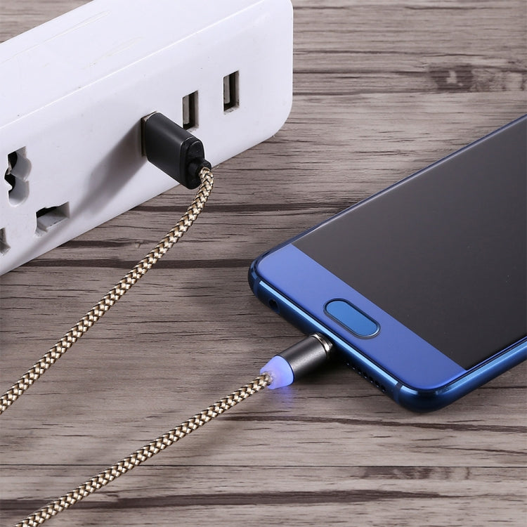 Micro USB magnetic charging cable plugged into wall adapter and phone, LED on, gold braid.