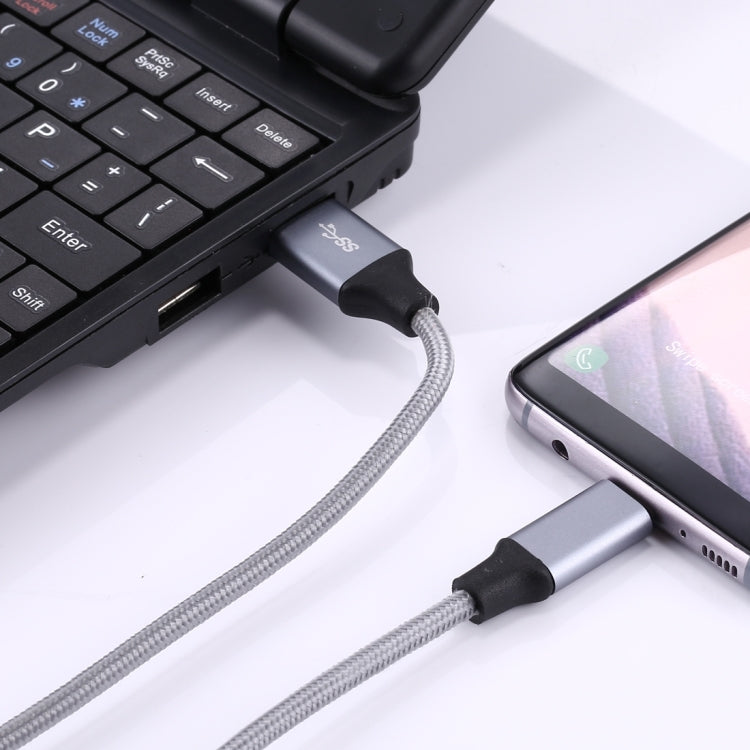 USB-C to USB 3.0 braided cable connected to laptop USB port and a smartphone USB-C port