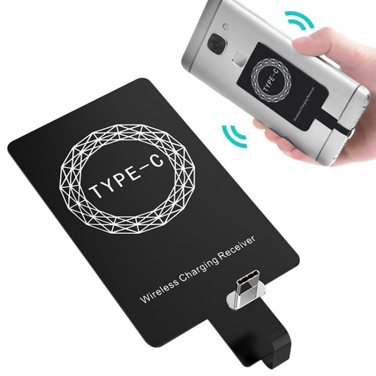 Type-C wireless charging receiver adapter, black, held in hand with charging pins visible